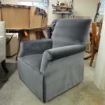 Custom built swivel rocker with tight seat and back and drop skirts.