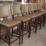 Set of six custom built barstools in leather with baseball stitched detail and  custom finiished walnut frames.